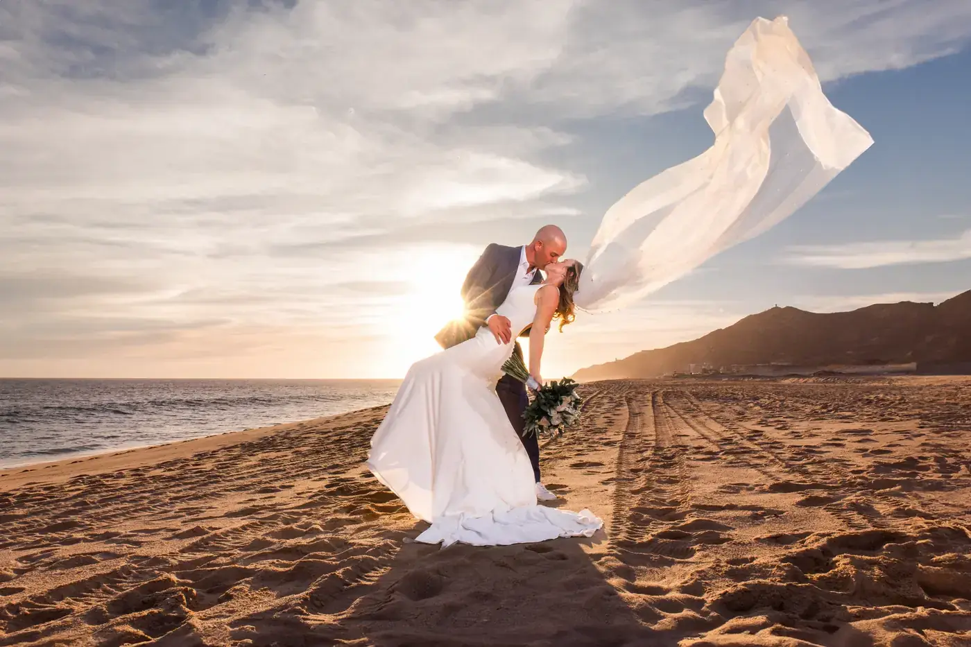 Bride and groom with a flowing veil at sunset, Cabo San Lucas wedding