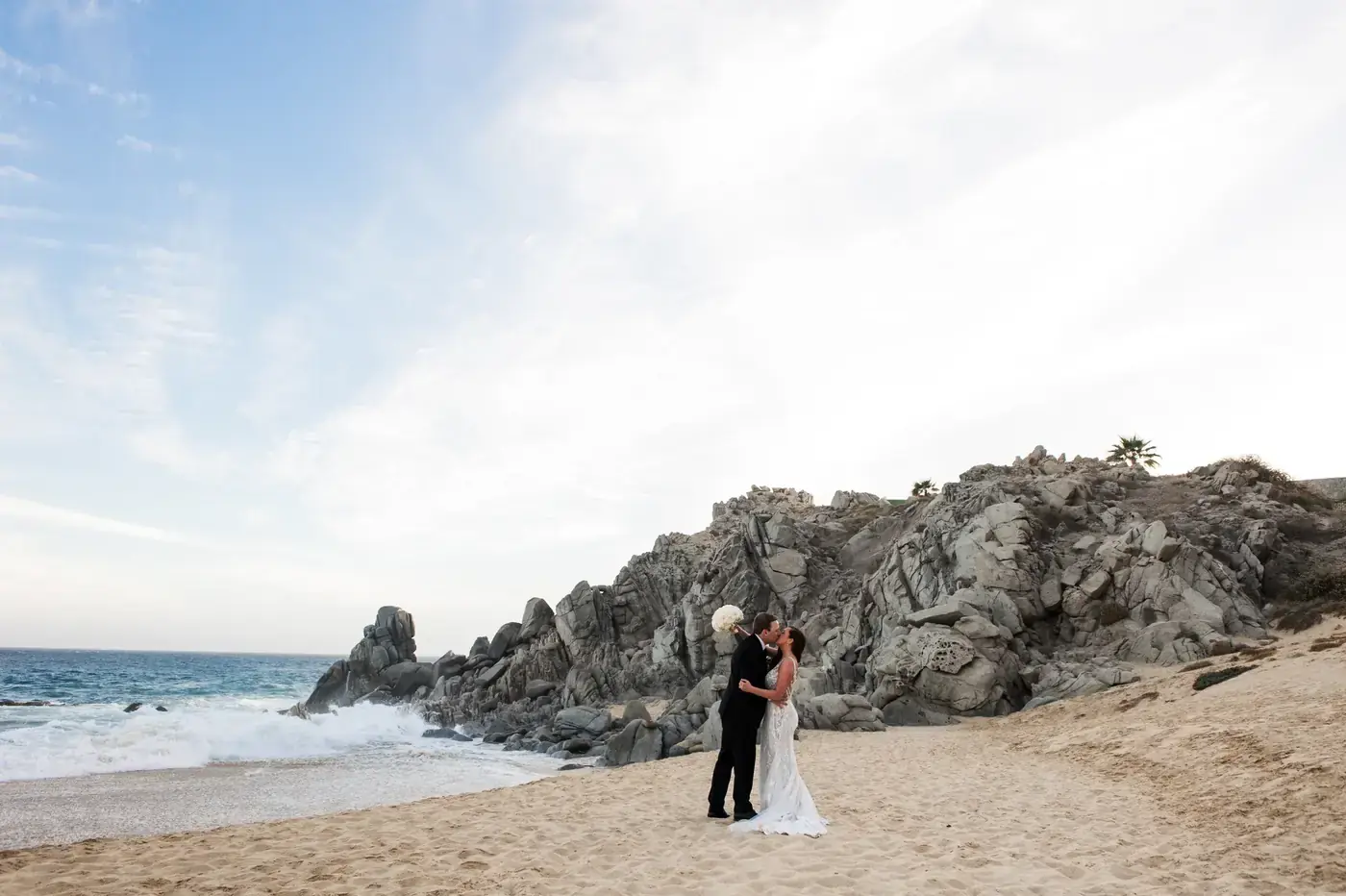 Couple kissing on the cliffs during a Cabo elopement