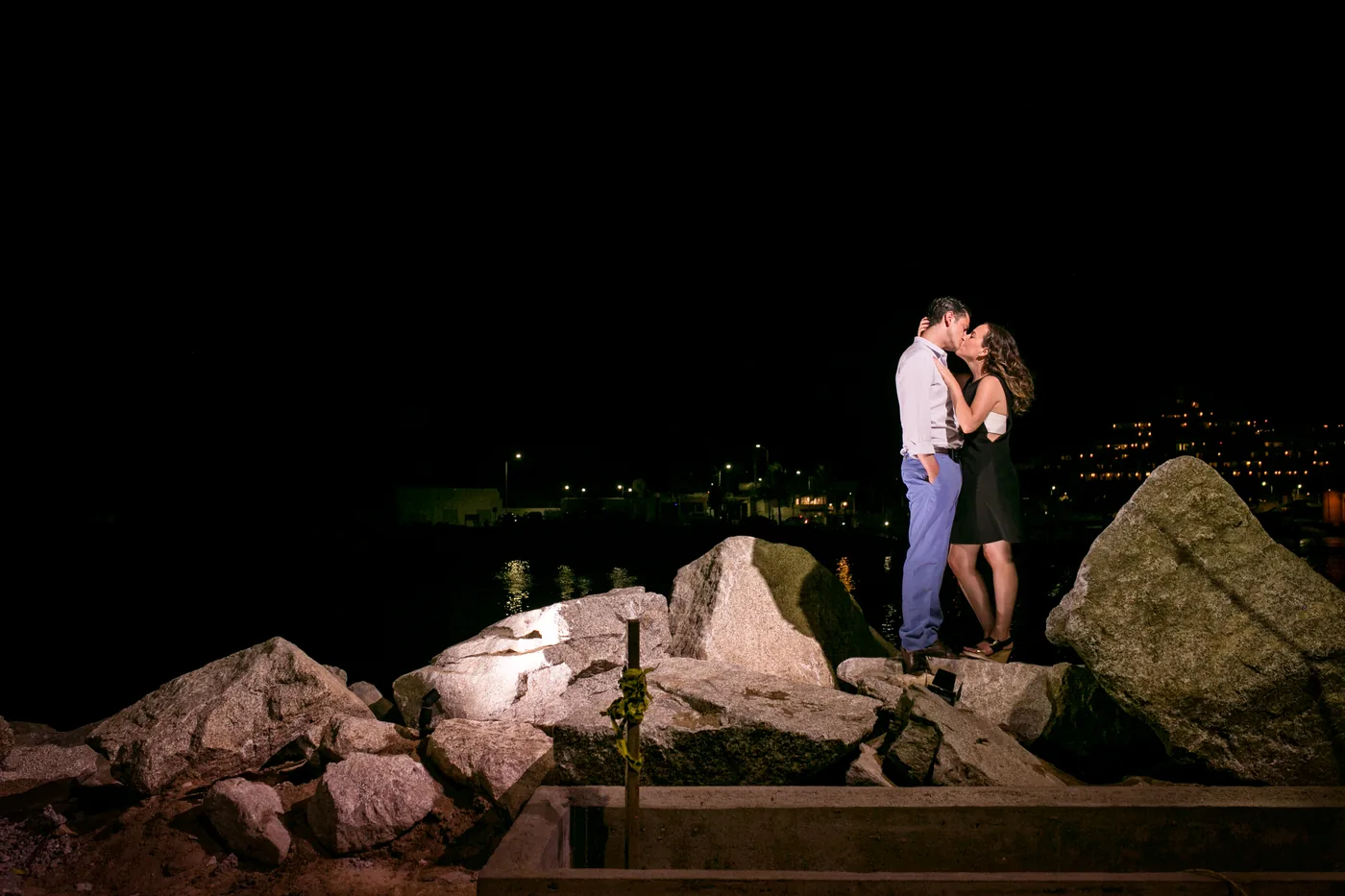 Couple celebrating on the rocks at night near Breathless Cabo San Lucas
