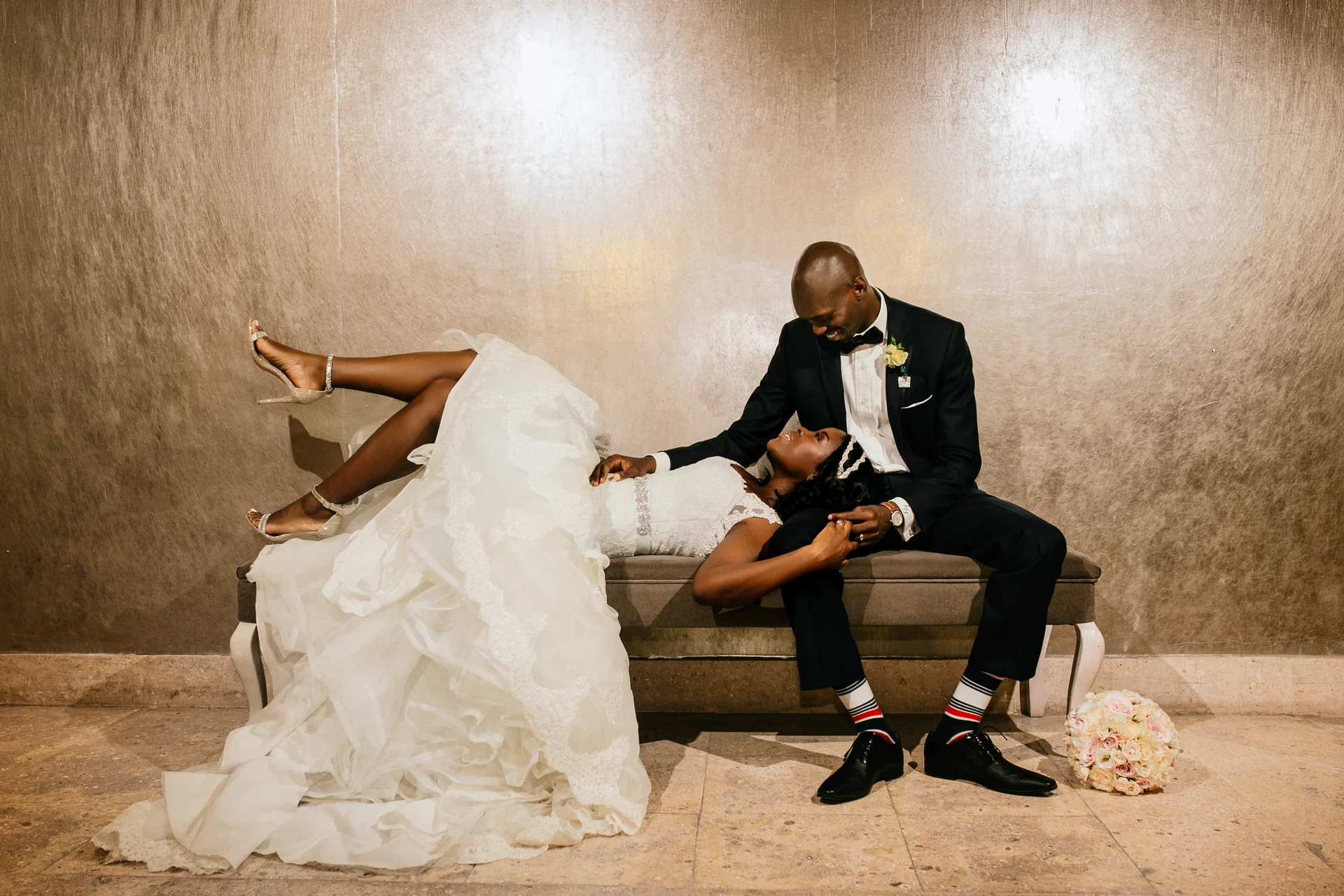 Bride and groom laughing on a bench at their Los Cabos wedding