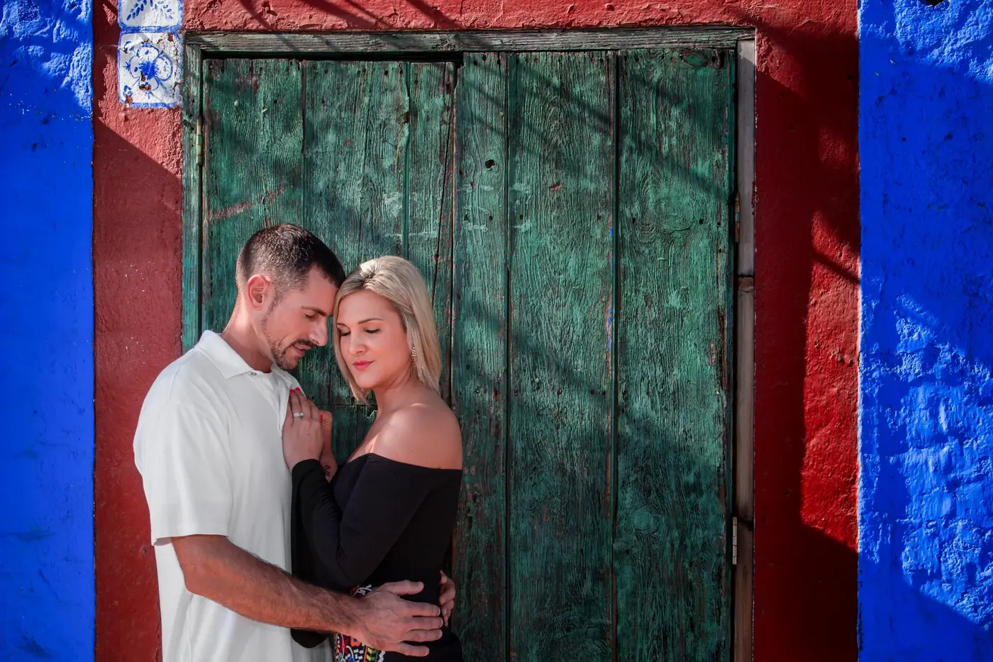 Couple embracing at a colorful doorway, Cabo San Lucas couples session