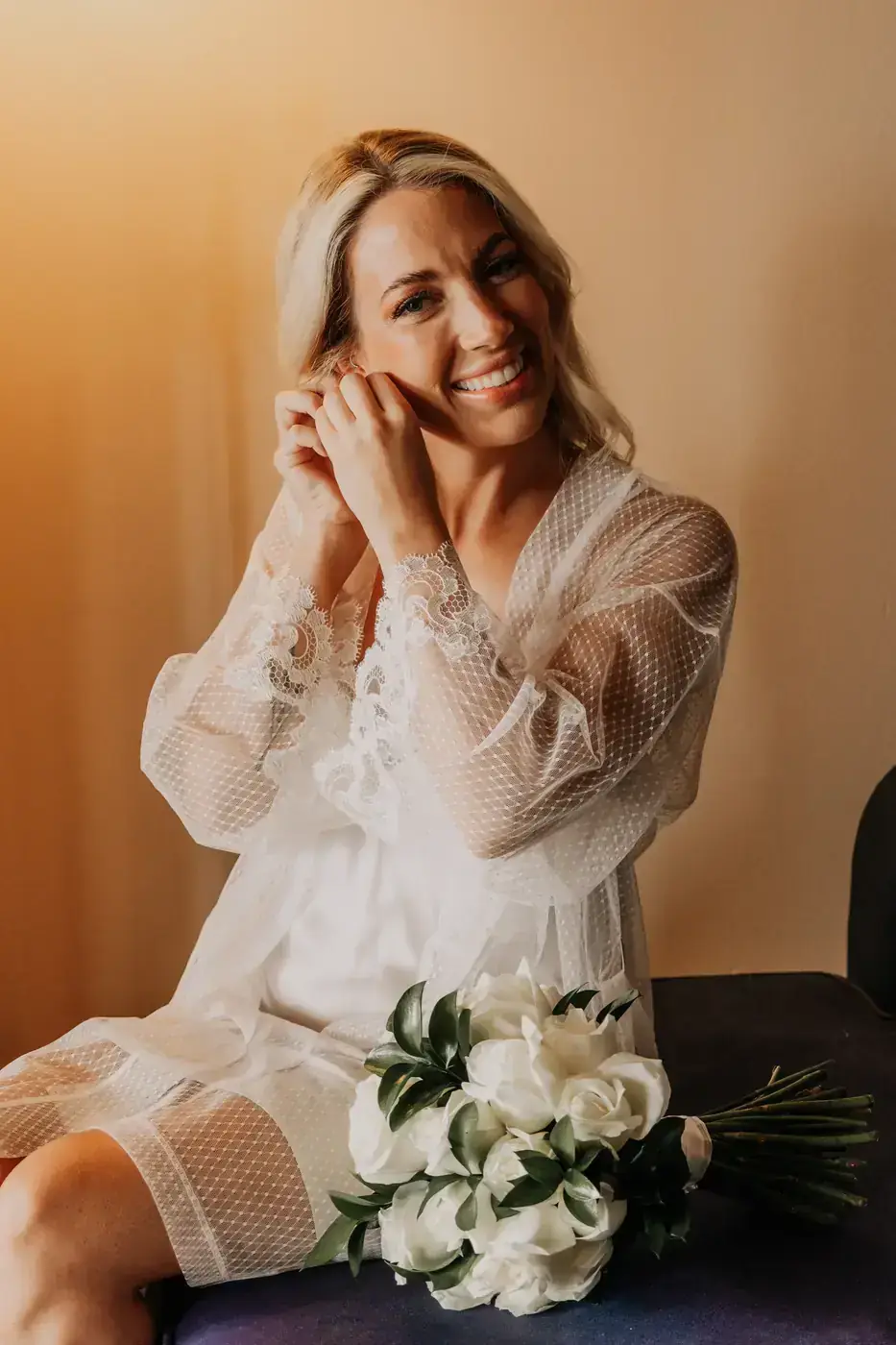 Bride laughing under her veil in a portrait before her beach ceremony in Cabo San Lucas