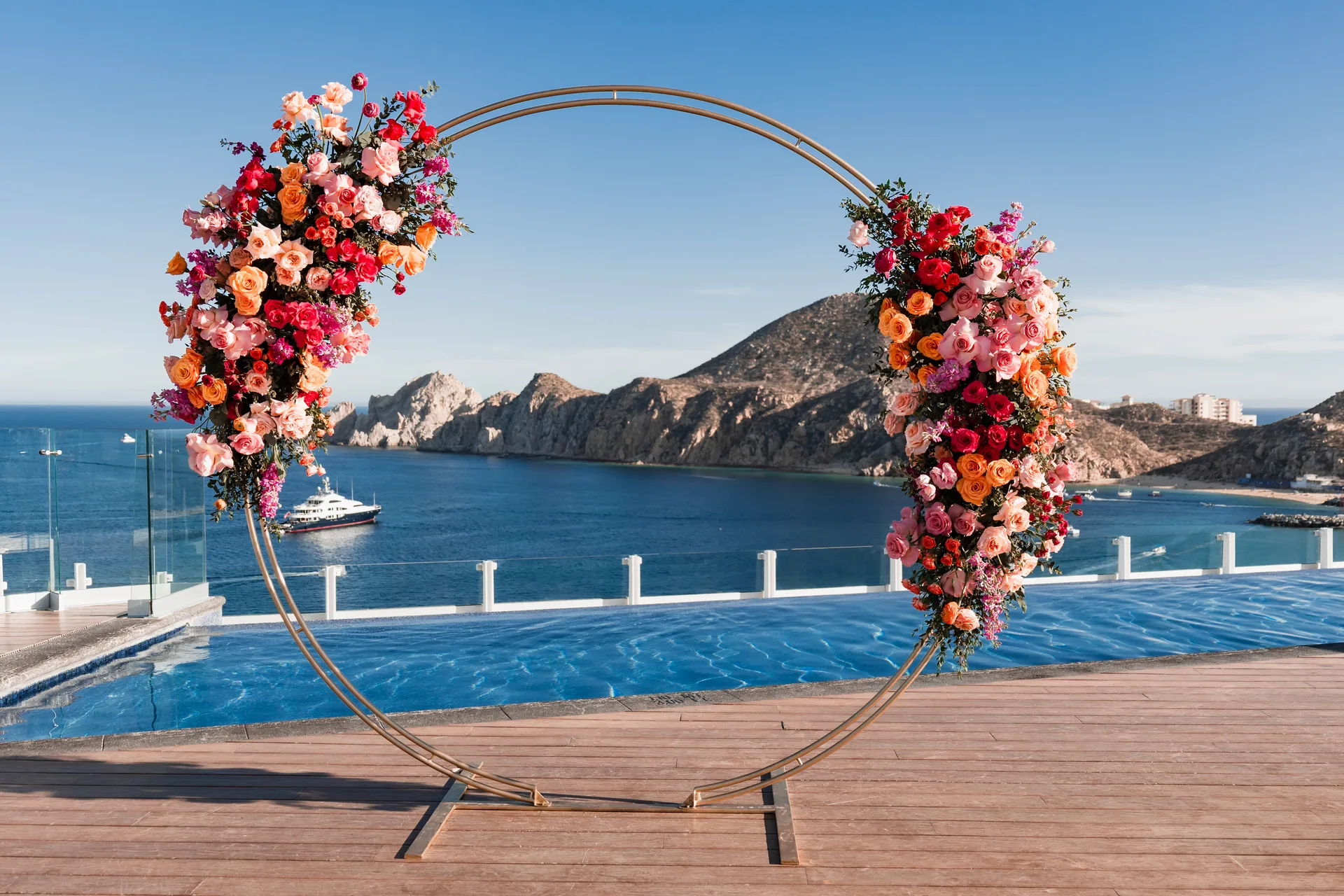 Floral wedding arch with El Arco in the background at Corazón Cabo