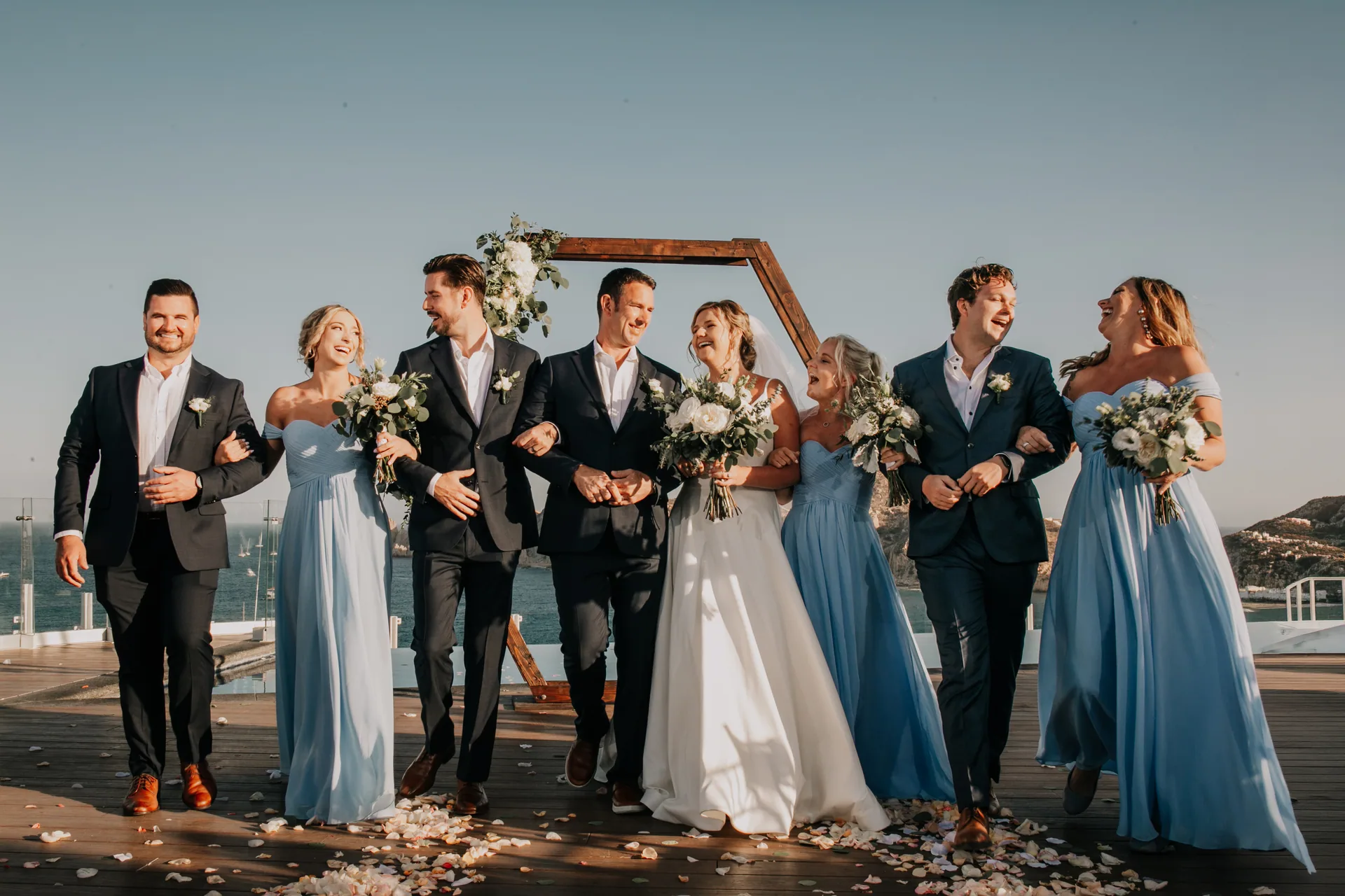 Wedding party walking together on the sand in Los Cabos
