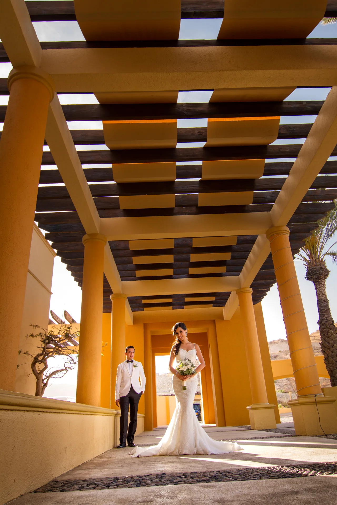 Bride and groom in the arched corridor at Fiesta Americana Los Cabos