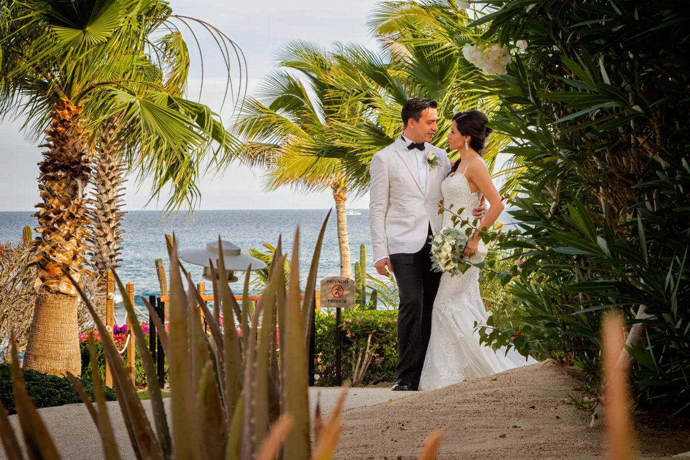 Bride and groom on the yellow wall at Fiesta Americana Los Cabos