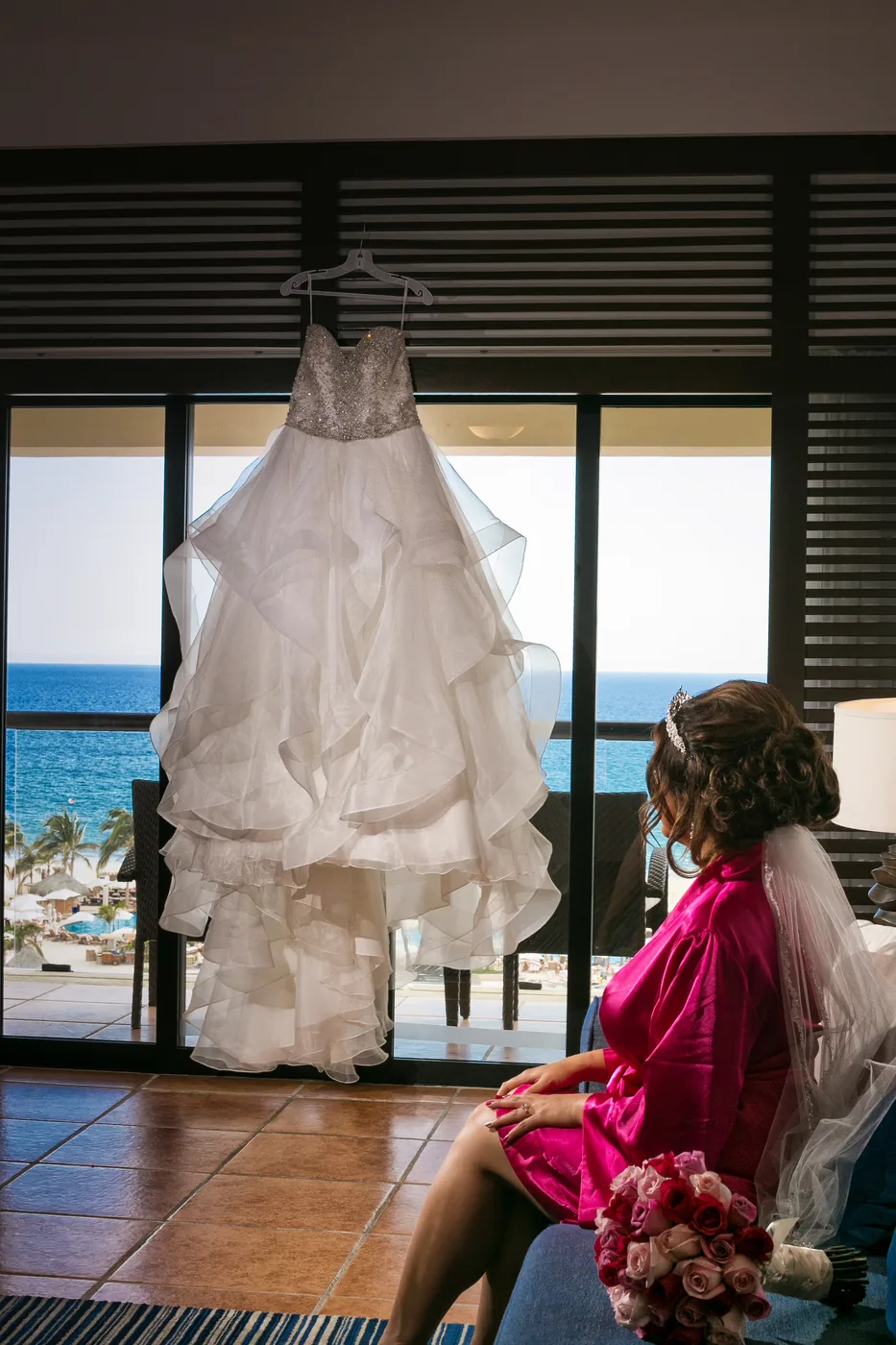 Wedding dress hanging in the window light at Hyatt Ziva Los Cabos