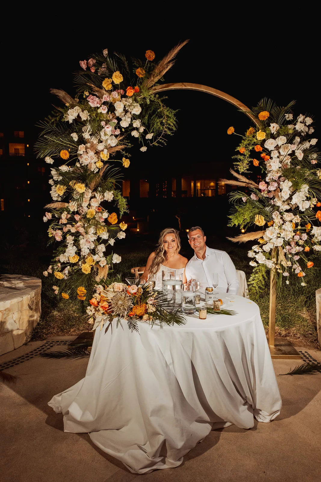 Couple at the floral arch at night at Pueblo Bonito Pacífica, Cabo San Lucas