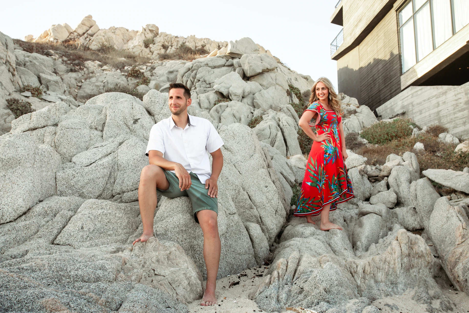 Couple sitting on the granite rock formations above the beach at Playa Monumentos, Cabo San Lucas