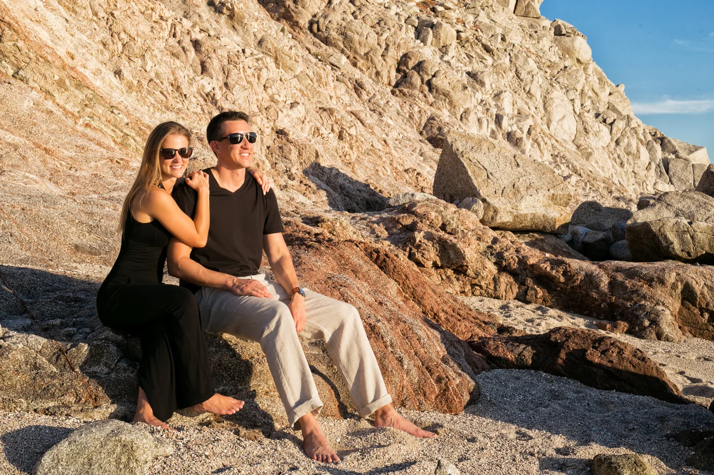 Engaged couple on the rocks at Monuments Beach near The Cape in Cabo San Lucas