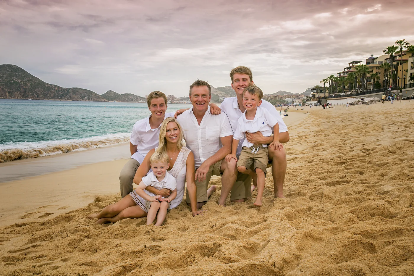 Extended family laughing on the sand at Villa del Palmar Cabo